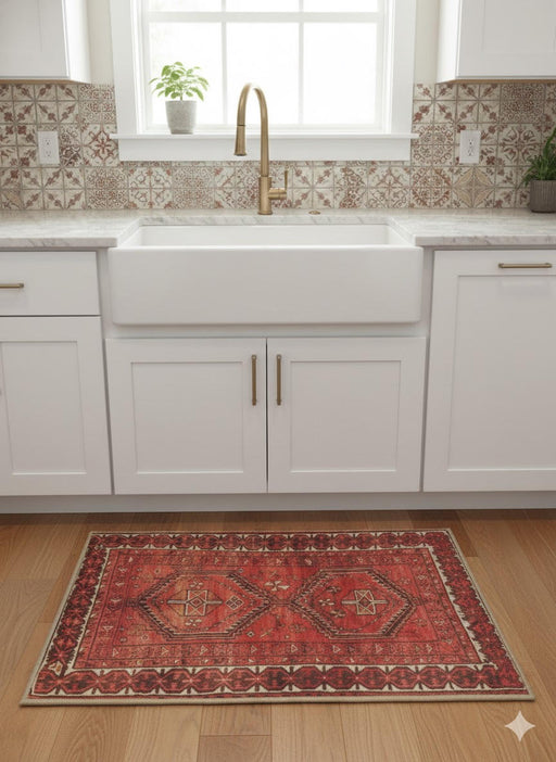 2' x 3' Rectangle Red Black Ivory Tribal Geometric Traditional Area Rug placed in front of a kitchen sink in a bright farmhouse kitchen.