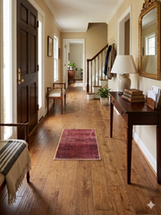 2' x 3' Rectangular Red & Black Geometric Medallion Traditional Washable Area Rug placed in an entryway hallway with a console table, mirror, and warm wood flooring.