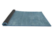 4' Round Denim Blue Contemporary Modern Area Rug displayed in a rolled product view on a white background.