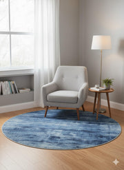 4' Round Denim Blue Soft Gray Hints of Ivory Ombre Textured Area Rug placed in a cozy living room reading nook setting.