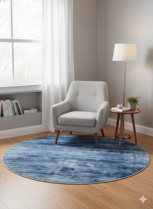 4' Round Denim Blue Soft Gray Hints of Ivory Ombre Textured Area Rug placed in a cozy living room reading nook setting.