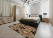 4' x 6' Bronze Brown Pink Patterned Super Soft Cloud Area Rug styled in a modern bedroom setting, highlighting the geometric floral-inspired pattern in bronze brown, pink, and green tones.