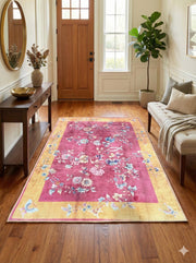 4' x 6' rectangular pink & golden yellow ivory vintage floral traditional area rug placed in a bright entryway beneath a wood console table and round mirror.