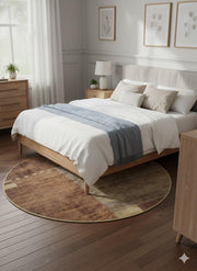 5' Round Brown & Beige Geometric Distressed Modern Area Rug placed beneath a wooden bed in a light neutral bedroom, showcasing the soft distressed texture and modern geometric design.