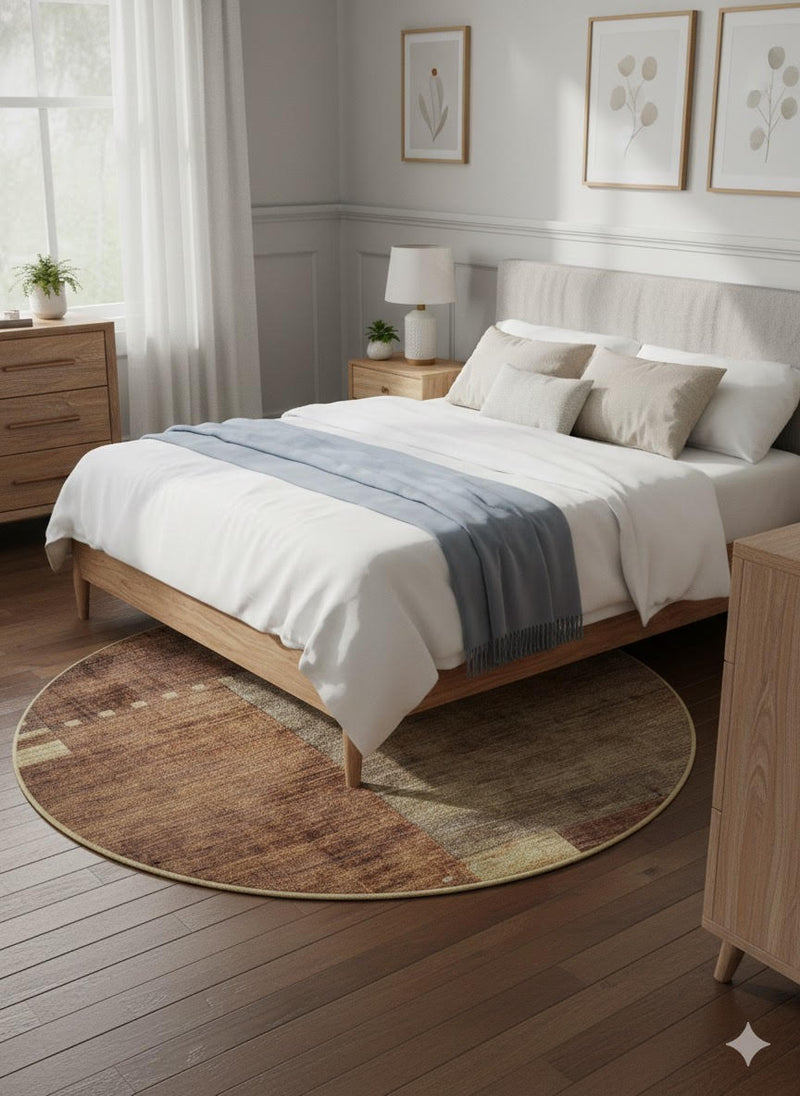 5' Round Brown & Beige Geometric Distressed Modern Area Rug placed beneath a wooden bed in a light neutral bedroom, showcasing the soft distressed texture and modern geometric design.