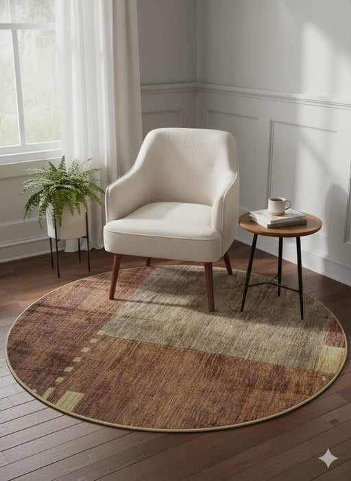 5' Round Brown & Beige Geometric Distressed Modern Area Rug styled in a bright reading corner with a cream accent chair and small side table, highlighting the warm brown and beige abstract block pattern.