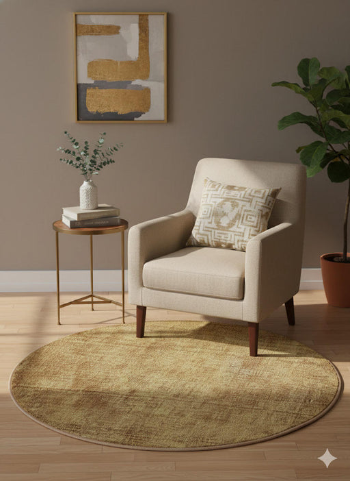 5' round soft golden ochre and warm honey washable solid textured area rug styled in a cozy reading nook with a neutral accent chair, gold side table, and warm minimalist décor.