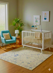 5' x 5' Square Blue & Ivory Cream Abstract Modern Area Rug placed in a soft neutral nursery with a white crib, rocking chair and a light wood floors.