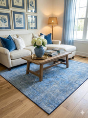 5' x 5' Square Blue Ivory Muted Slate Faint Gray Distressed Area Rug placed in a cozy living room with light wood flooring and natural light 
streaming through the windows.