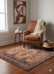 5' x 5' Square Terracotta with Charcoal, Rust, and Warm Brown accents Southwestern geometric pattern vintage-inspired area rug placed in a cozy living room corner with warm wood flooring, an upholstered rust-toned accent chair, a small round wooden side table with stacked books and a plant, neutral walls, and framed abstract artwork softly lit by natural window light.