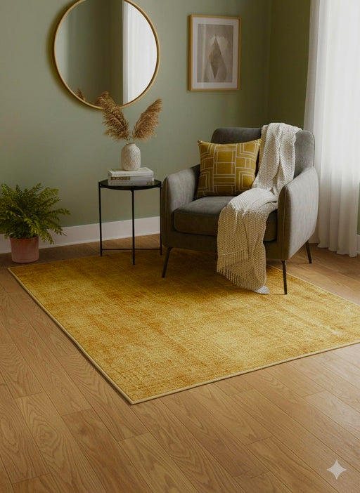 5' x 5' square mustard yellow & warm gold solid modern area rug styled in a cozy living room beneath a gray accent chair with a round mirror, side table, and soft neutral decor.