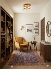 5' x 5' square navy blue & red floral medallion traditional area rug placed in a cozy entryway with a mustard accent chair, wood shelving, and warm lighting.