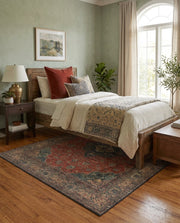 5' x 6' Rectangular Rust Red & Navy Blue Distressed Floral Medallion Traditional Area Rug placed in a bedroom with a rustic wooden bed and cream bedding.