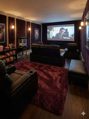 5' x 7.7' deep burgundy wine red undertones solid plush area rug placed in a home theater with leather recliners and dark wood flooring.