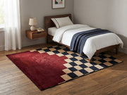 5' x 7' Rectangular Burgundy Black & Beige Checkered Geometric Modern Area Rug placed in a bedroom with a wooden bed and white bedding.