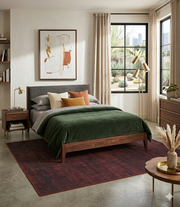 5' x 7' Rectangular Burgundy Red Distressed Solid Modern Washable Area Rug styled in a bedroom with warm wood furniture and cozy neutral accents.