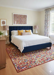 5' x 7' Rectangular Multi Color Confetti Pattern Contemporary Area Rug placed in a cheerful bedroom beneath a navy upholstered bed with white bedding, colorful accent pillows, patterned curtains, and warm wood flooring.
