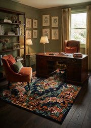 5' x 7' Rectangular Navy Blue & Rust Orange Floral Ornate Traditional Area Rug styled in a home office with a dark wooden desk and rust velvet chair.