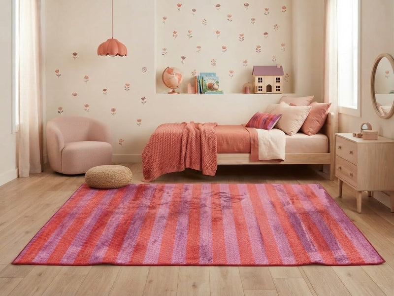 5' x 7' Rectangular Pink & Orange Purple Striped Abstract Modern Area Rug styled in a bedroom with a pink daybed and blush upholstered chair.
