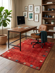 5' x 7' Rectangular Red Multicolor Distressed Solid Tribal Traditional Area Rug styled in a home office with a wooden desk and brown leather office chair.
