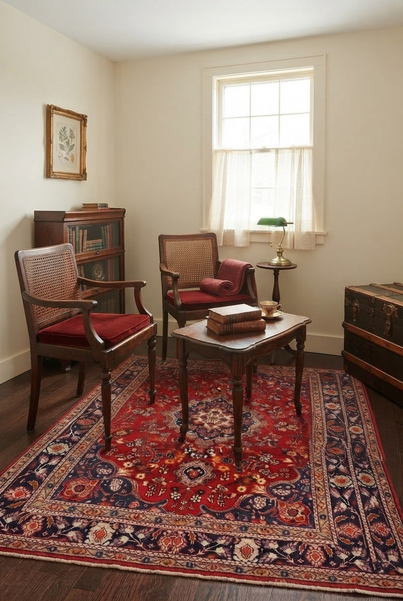 5' x 7' Rectangular Red Navy Blue Floral Medallion Traditional Oriental Washable Area Rug styled in a sitting room with two wooden accent chairs and a coffee table.