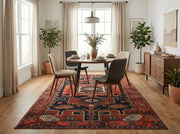 5' x 7' Rectangular Rust Red & Navy Blue Tribal Geometric Southwestern Washable Area Rug styled in a dining room with a round wooden table and upholstered chairs.