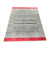 5' x 7' black, ivory, and red modern striped rectangular area rug featuring bold horizontal stripes and a color-blocked border on a clean white background.