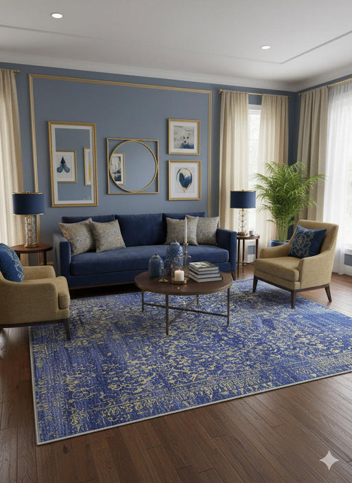 5' x 7' blue, gold, and beige distressed floral rectangular area rug styled in a refined living room with a blue sofa, accent chairs, and warm wood flooring.