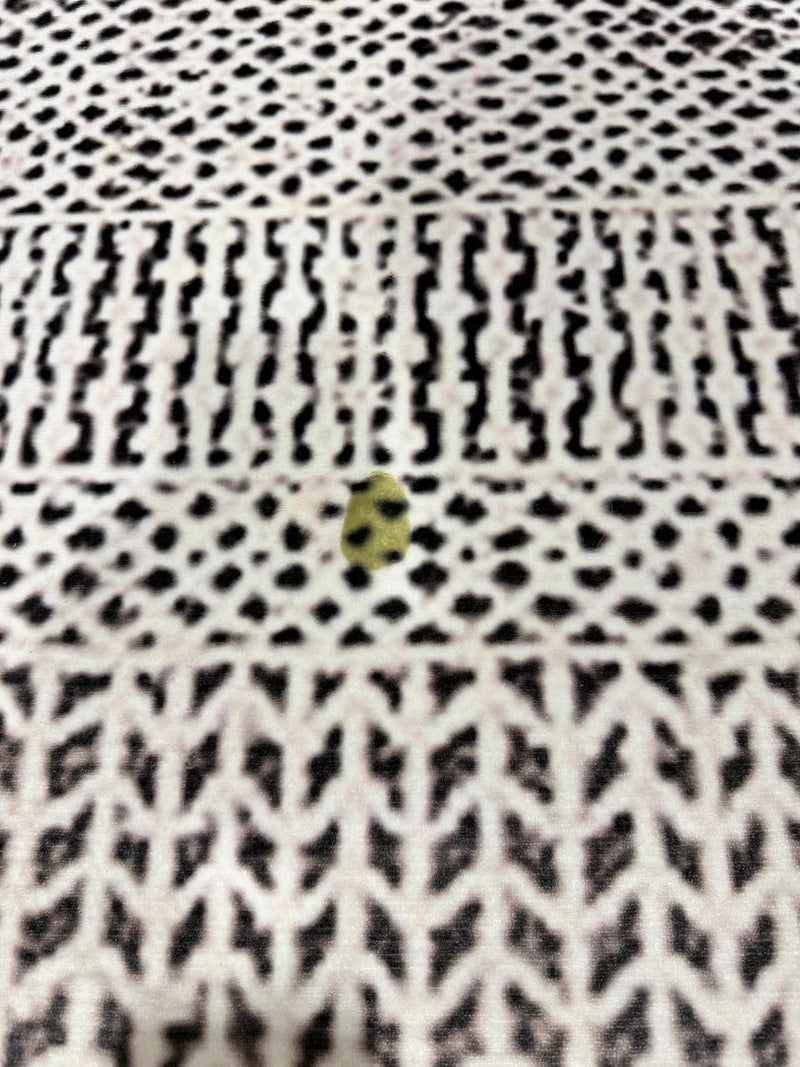 5' x 7' ivory and black charcoal geometric textured rectangular area rug close-up showing woven texture and contrasting geometric motifs.