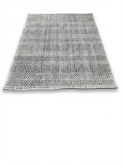 5' x 7' ivory and black charcoal geometric textured rectangular area rug featuring layered linear and dotted patterns on a white background.