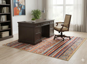 5' x 7' multi color striped geometric tribal rectangular area rug styled in a bright home office with a wooden desk, office chair, and light wood flooring.
