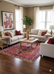 5' x 7' multi color traditional geometric area rug styled in a warm living room with neutral sofas, red accent pillows, a light wood coffee table, and hardwood flooring.
