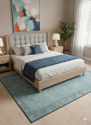 5' x 7' teal blue distressed traditional washable area rug styled beneath a light wood bed with neutral bedding and blue accent pillows.
