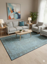 5' x 7' teal blue distressed washable area rug placed in a modern living room with neutral sofas, light wood furniture, and abstract wall art.