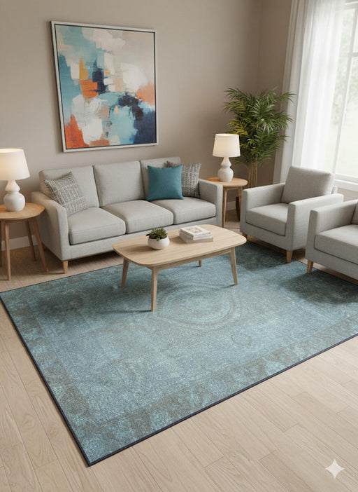 5' x 7' teal blue distressed washable area rug placed in a modern living room with neutral sofas, light wood furniture, and abstract wall art.