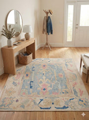 5' x 8' Light Blue Multi Color Pastel Distressed Area Rug placed / styled in a modern entryway with a wooden bench, round wall mirror, and potted plant.