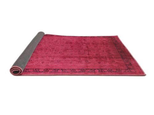 5' x 8' Pink Rose Mid-Century Modern Persian Area Rug rolled corner view highlighting the flexible backing and neatly finished edges.