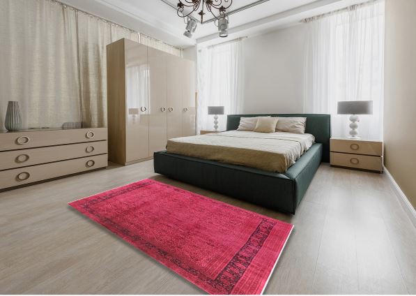 5' x 8' Pink Rose Mid-Century Modern Persian Area Rug styled in a contemporary bedroom setting, highlighting the vibrant pink rose tones and vintage Persian-inspired border design.