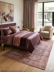 5' x 8' Rectangular Brown Beige Distressed Modern Abstract Area Rug displayed in a bedroom beneath a bed with coordinated mauve bedding.