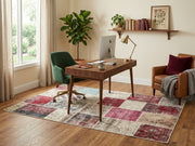 5' x 8' Rectangular Burgundy Pink & Beige Distressed Patchwork Vintage Area Rug styled in a home office with a wooden desk and green office chair.