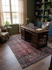 5' x 8' Rectangular Charcoal Black & Burgundy Red Distressed Tribal Geometric Vintage Area Rug styled in a home office with a dark wooden desk and leather office chair.