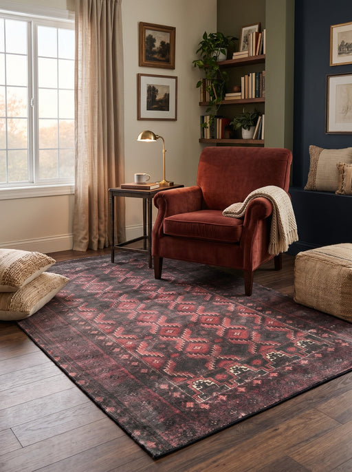 5' x 8' Rectangular Charcoal Black & Burgundy Red Distressed Tribal Geometric Vintage Area Rug styled in a living room with a burgundy accent chair and side table.