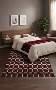 5' x 8' Rectangular Dark Brown & Blush Pink Geometric Grid Modern Area Rug placed in a bedroom with a wooden bed and white bedding.