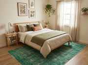 5' x 8' Rectangular Emerald Green & Sage Green Distressed Abstract Modern Area Rug placed in a bedroom with a wooden bed and cream bedding.
