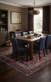 5' x 8' Rectangular Navy & Burgundy Distressed Geometric Medallion Vintage Washable Area Rug styled in a dining room with a wooden dining table and navy upholstered chairs.