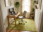 5' x 8' Rectangular Olive Green & Sage Green Distressed Solid Modern Area Rug styled in a home office with a wooden desk and white office chair.