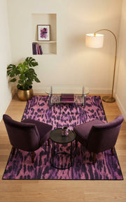 5' x 8' Rectangular Pink & Purple Animal Print Modern Contemporary Area Rug styled in a living room with purple accent chairs and a glass coffee table.