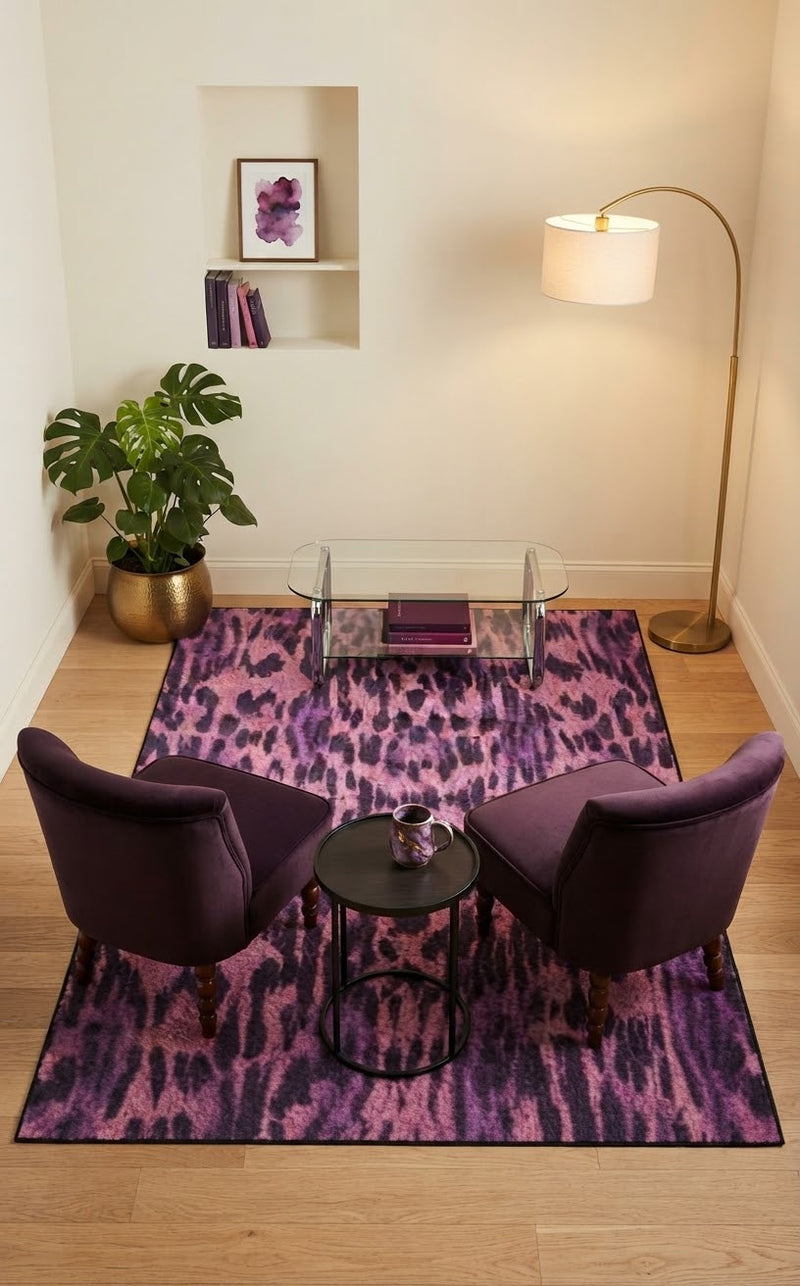 5' x 8' Rectangular Pink & Purple Animal Print Modern Contemporary Area Rug styled in a living room with purple accent chairs and a glass coffee table.