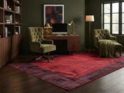 5' x 8' Rectangular Red & Burgundy Distressed Solid Border Modern Area Rug styled in a home office with a wooden desk and olive green chairs.