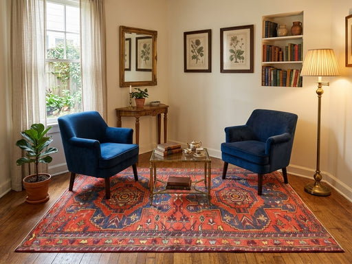 5' x 8' Rectangular Rust Red & Navy Blue Geometric Medallion Southwestern Area Rug styled in a living room with two blue accent chairs and a glass coffee table.